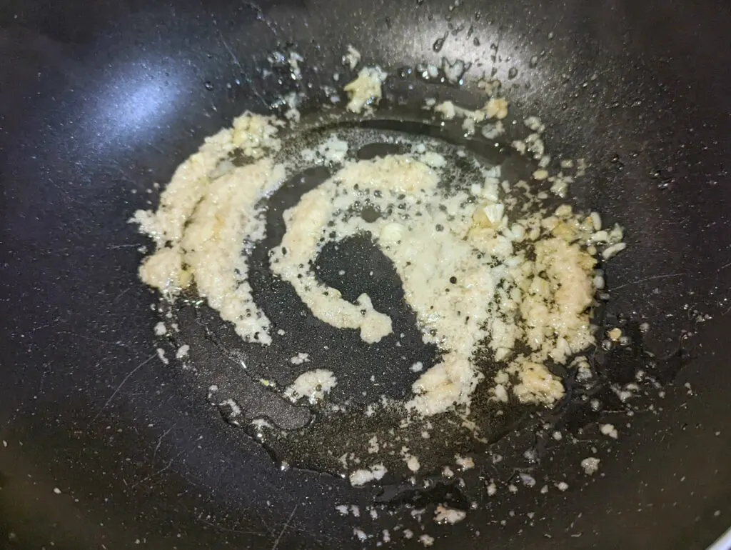 Ginger and garlic cooking in a wok.