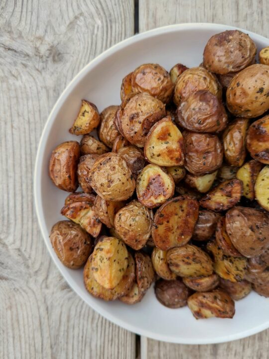 A plate full of roasted potatoes.