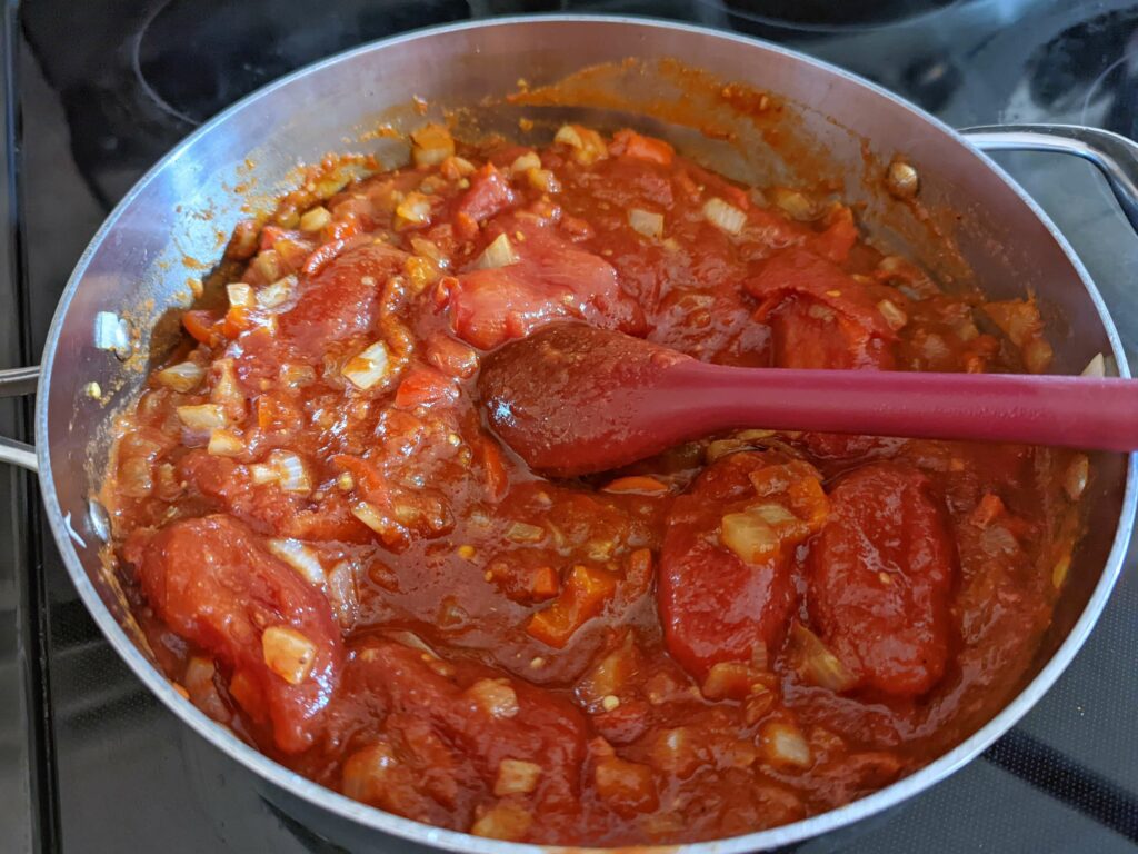 Add the hand-crushed tomatoes to the pan.