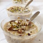 Small bowls with sheer khurma garnished with almond and pisatchio..