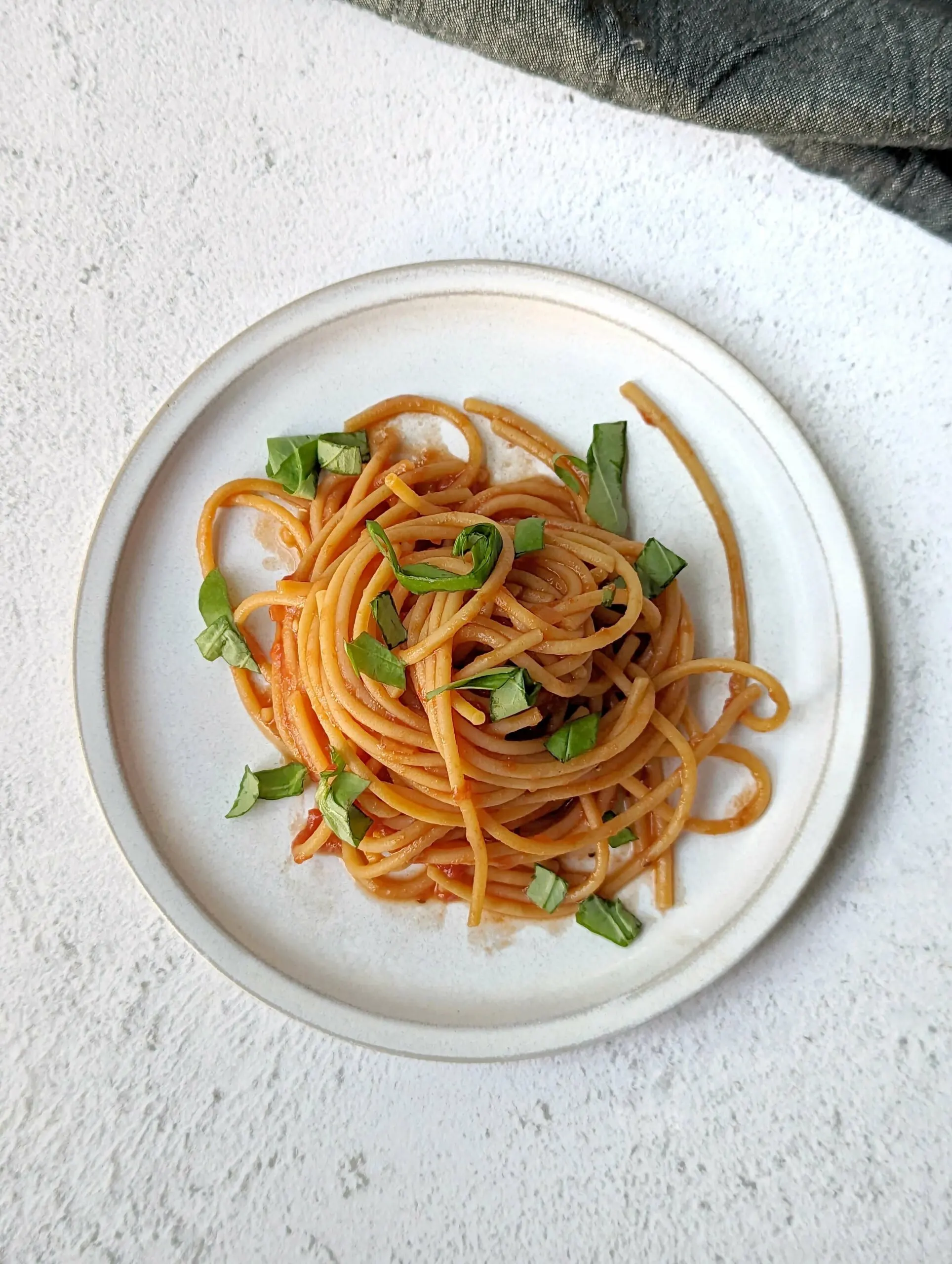 Sugo al Pomodoro coated  noodles and topped with basil. 