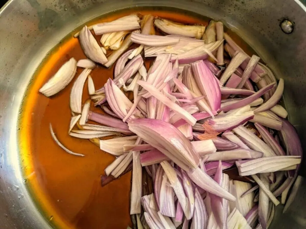 Add shallots, lemongrass, and ginger to the mixture and simmer.