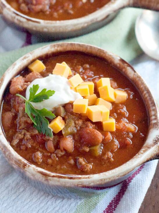 Family Favorite Chili in a bowl with chunks of cheese and sour cream.