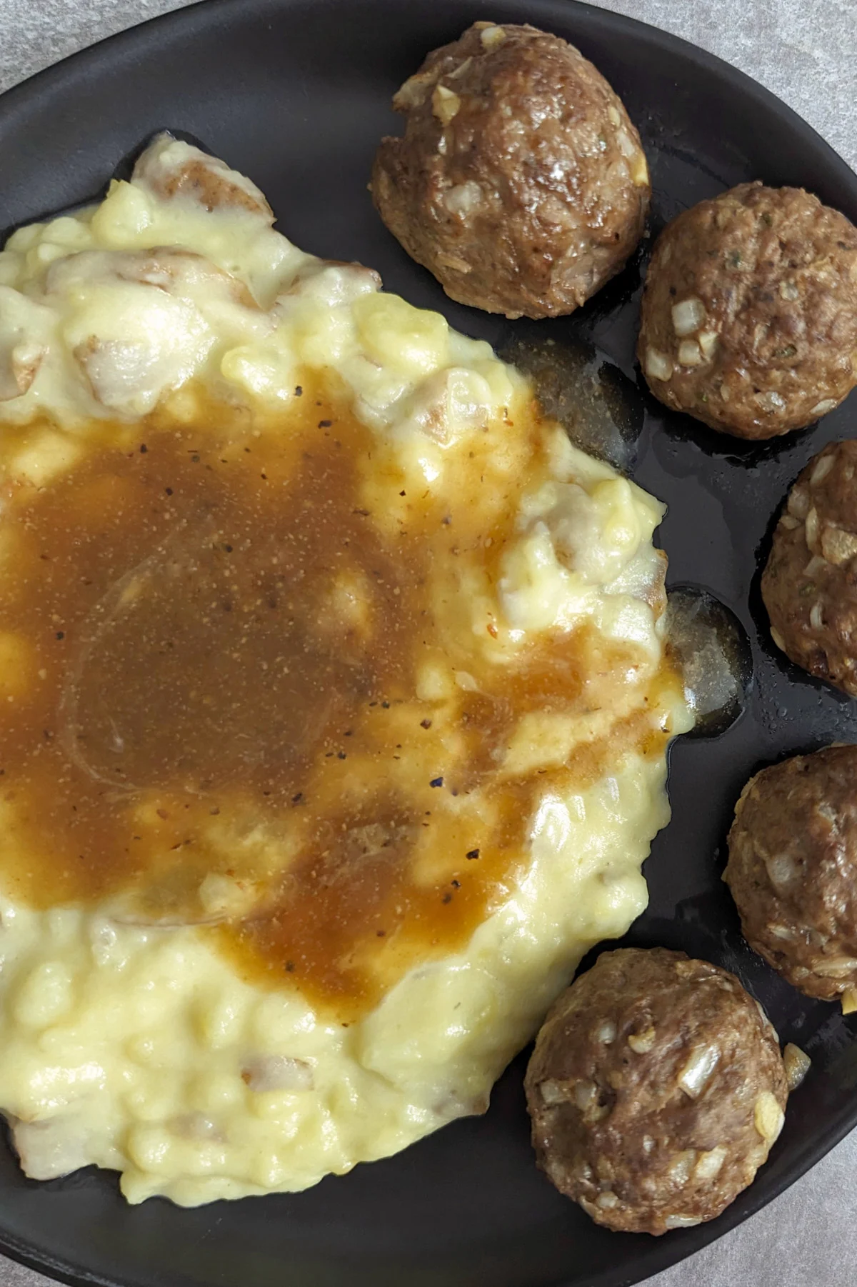 Meatballs and mashed potatoes with homemade brown gravy.