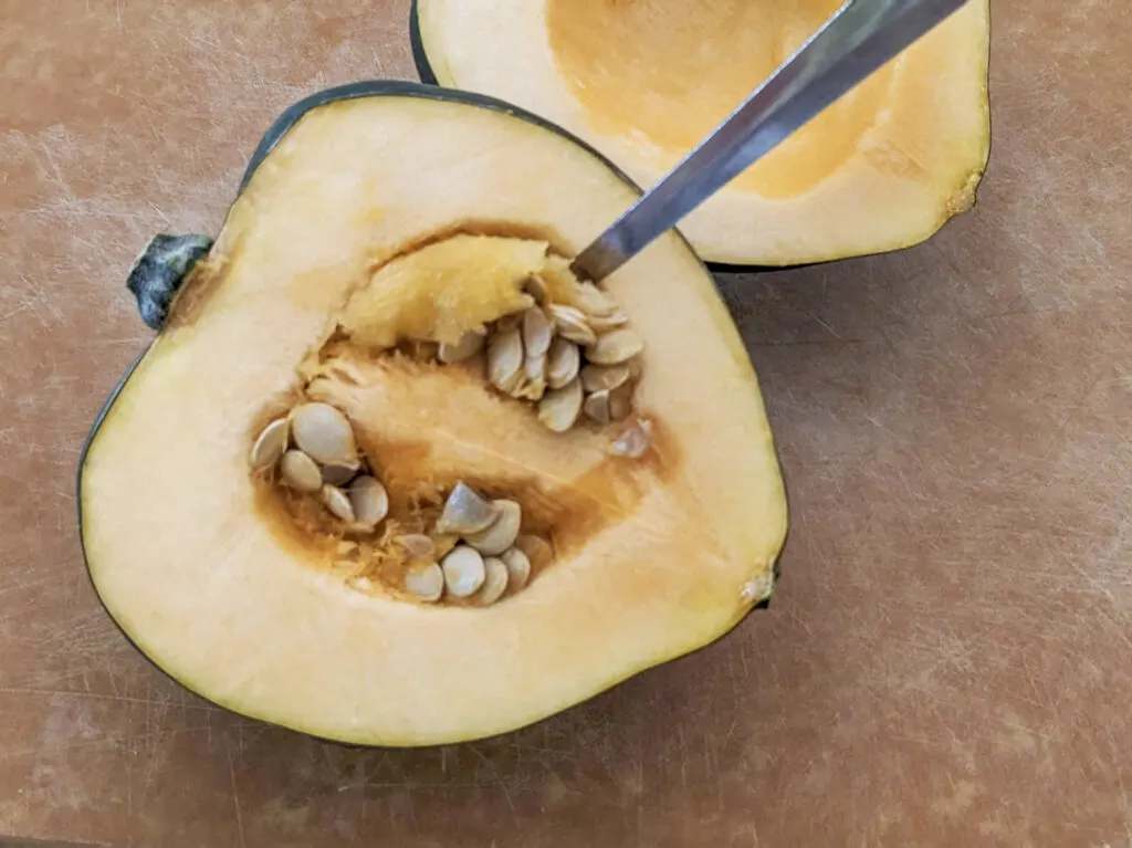 Scooping the seeds out of the acorn squash.