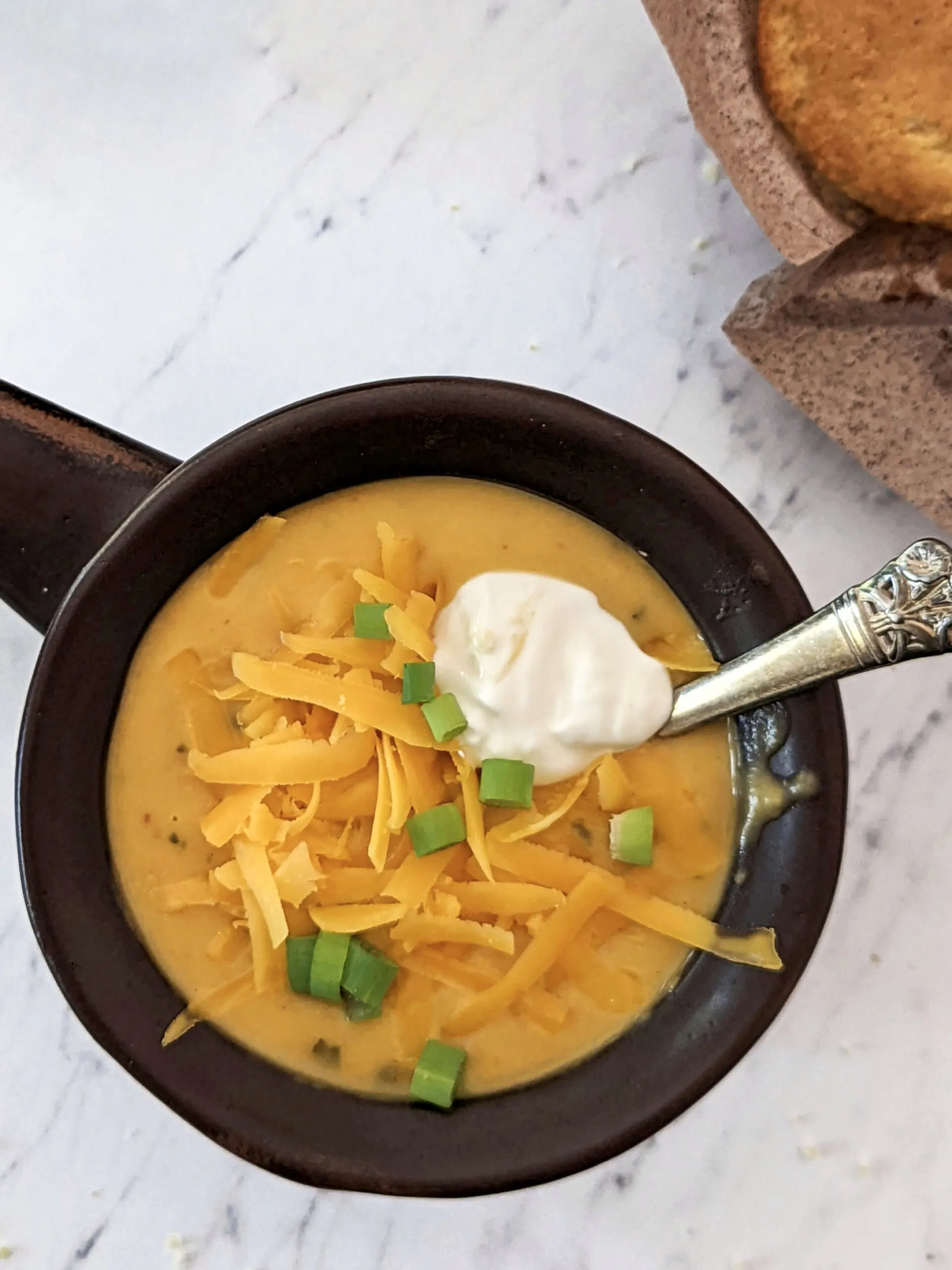 Two bowls of instant pot potato soup with toppings.