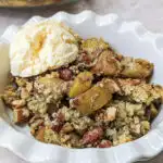 A scoop of keto apple crisp topped with keto ice cream and the crisp in the background.