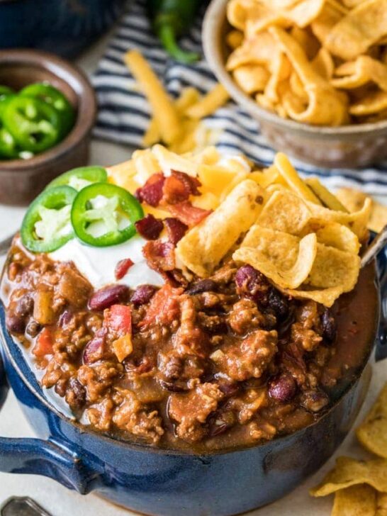 The best chili topped with sour cream, corn chips, jalapeño, and bacon.