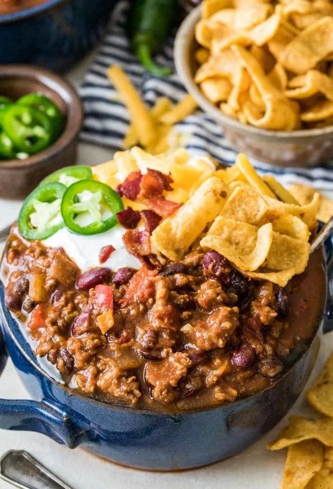 The best chili topped with sour cream, corn chips, jalapeño, and bacon.