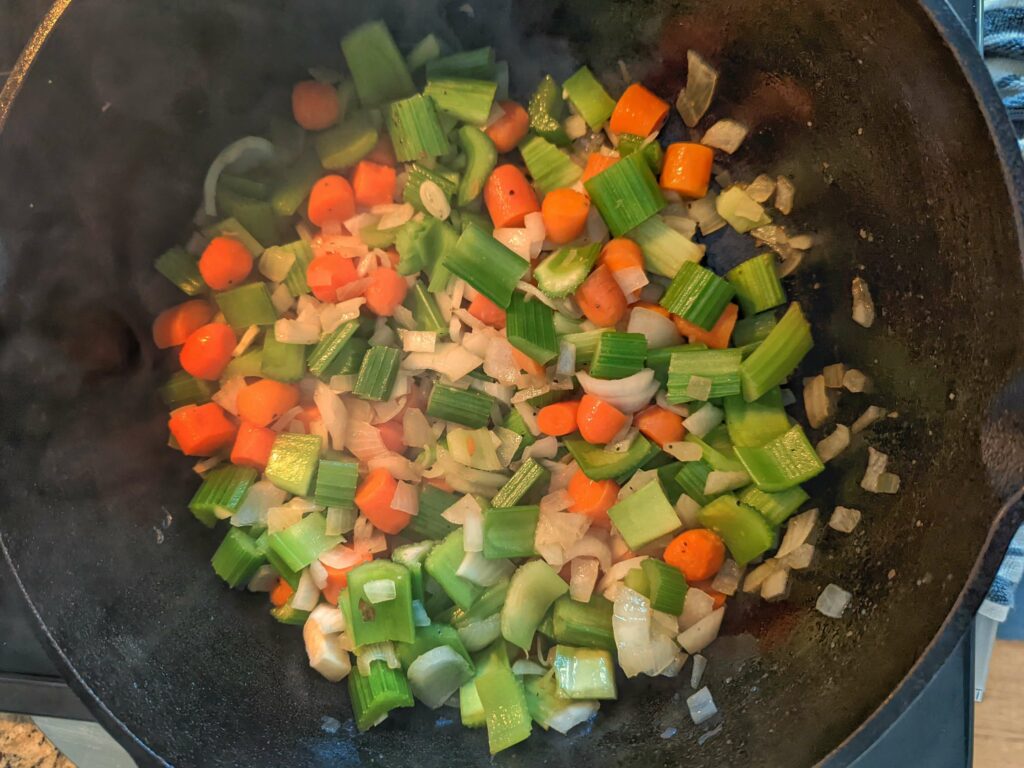 Saute onion, carrot, celery, and garlic in a pan.