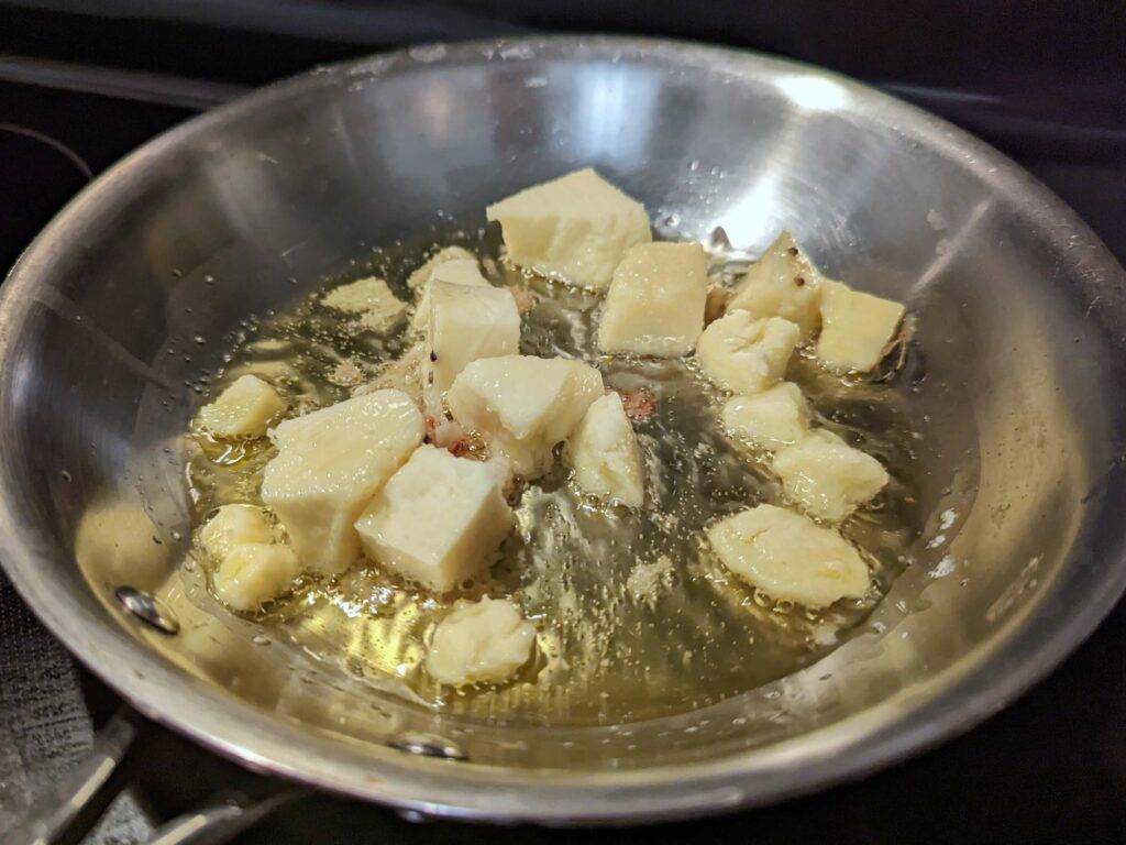 Khoya frying in a skillet with ghee.