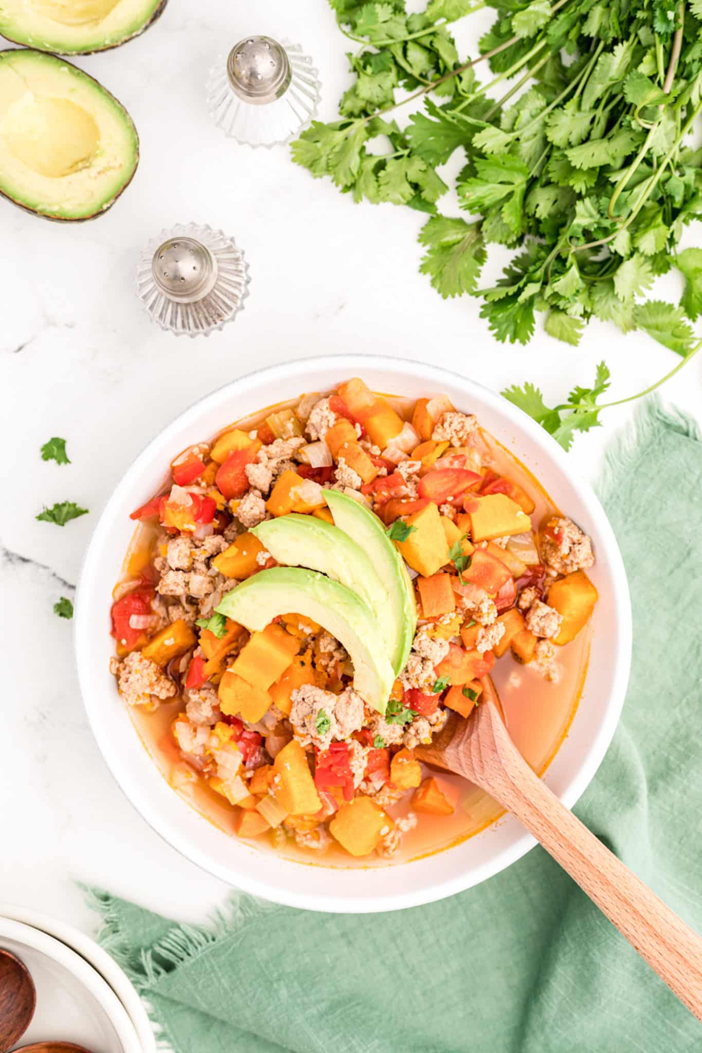 An overhead shot of turkey chili topped with avocado slices.