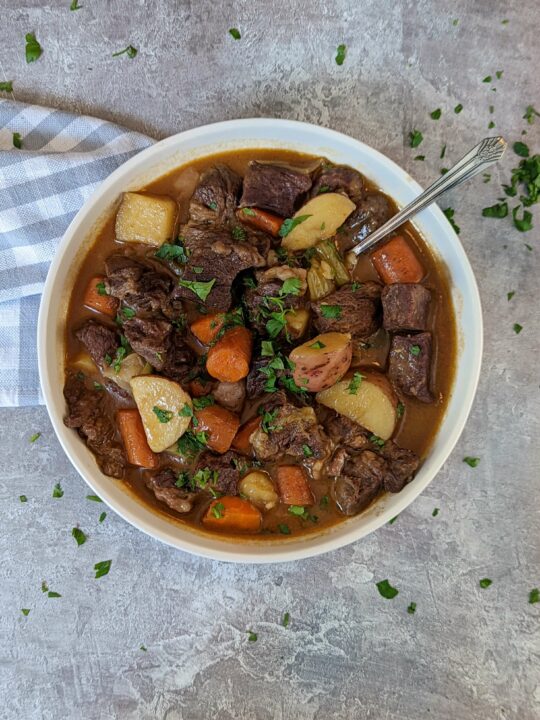 A bowl of Instant Pot beef strew garnished with parsley.