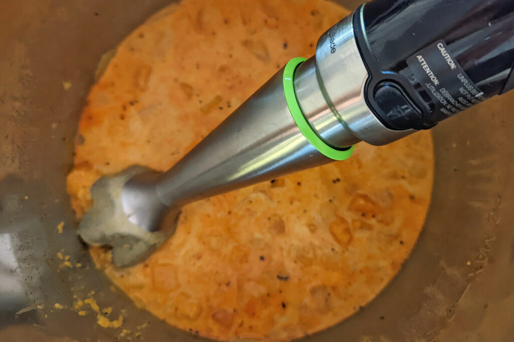 Pureeing the soup with an Immersion blender.