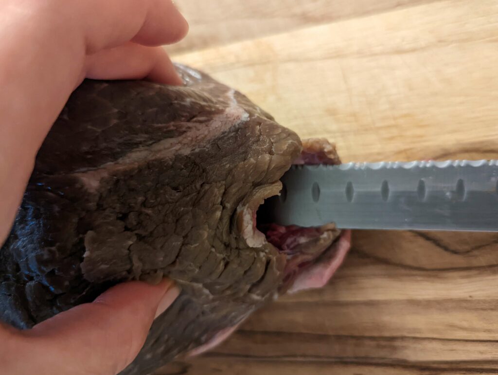Using a knife to insert into the roast.