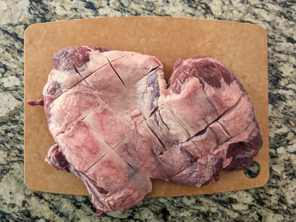 Leg of lamb with crisscross cuts in the top.