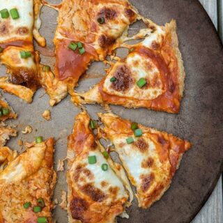 Buffalo chicken crust pizza cut into slices and spread apart on a pan.