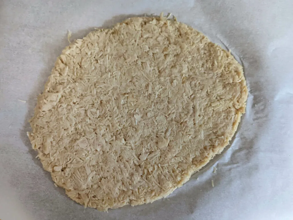 The chicken crust formed into a circle on the baking sheer.