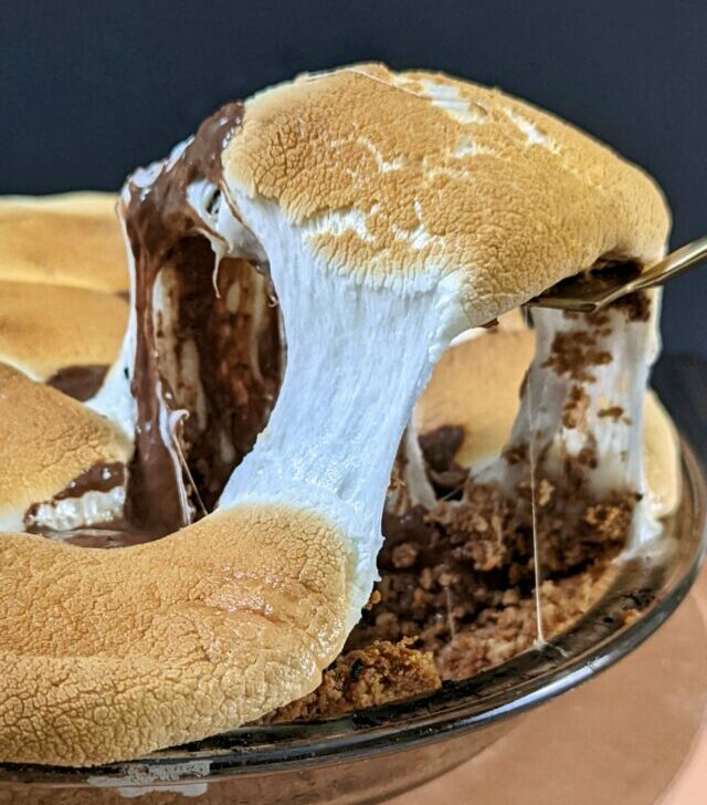 A slice of smores pie being scooped out of the pie dish.