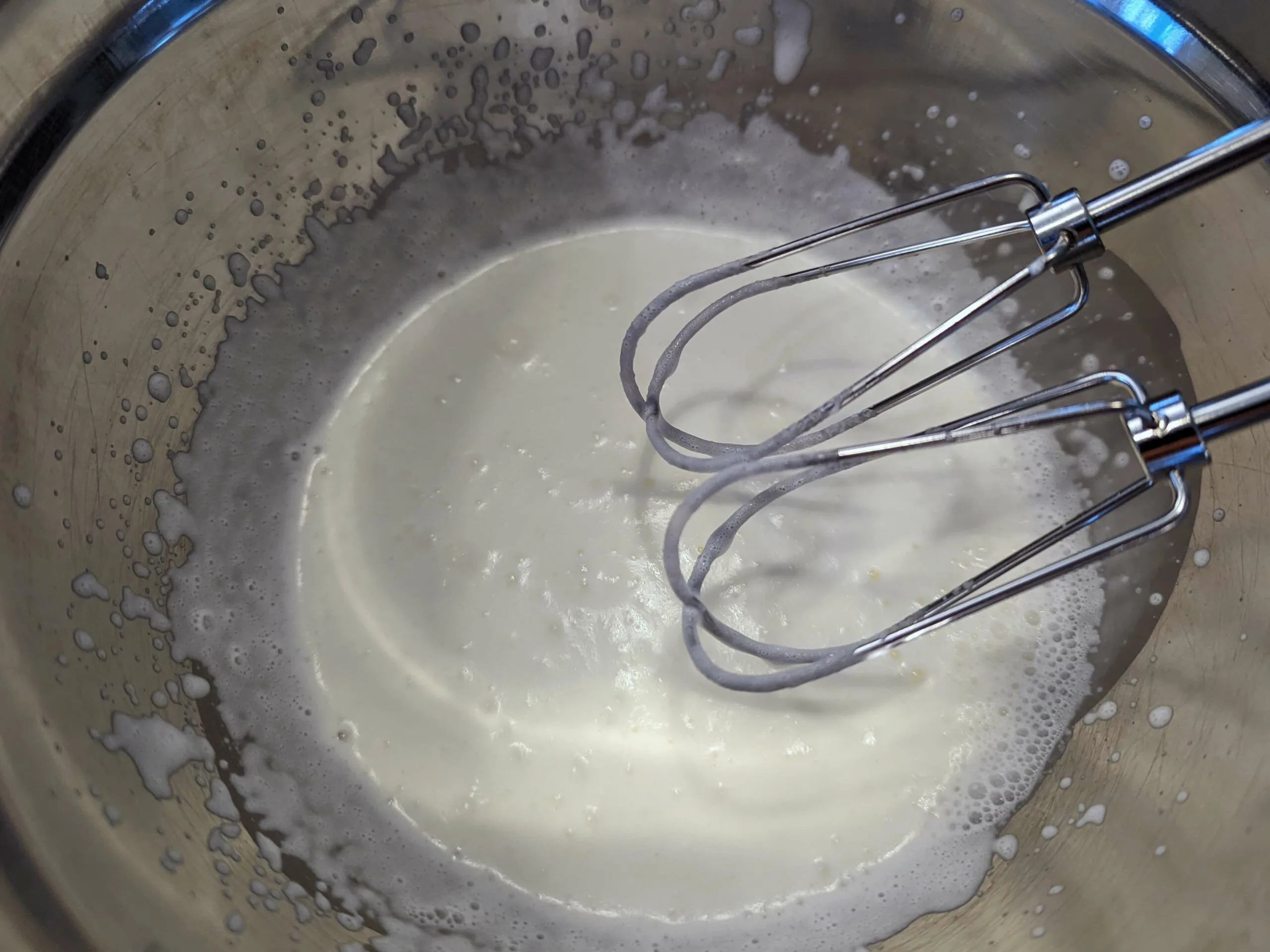 Whipped heavy cream in a mixing bowl.