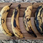 Ripe plantains on a cutting board.