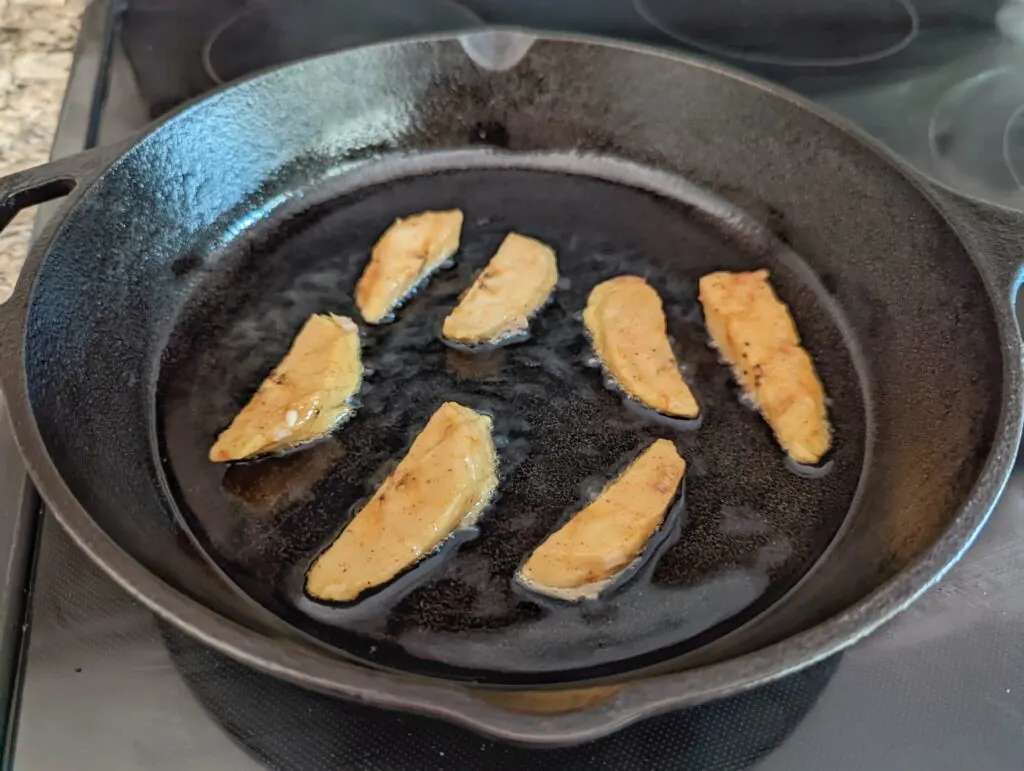 Plantains frying in a skillet.
