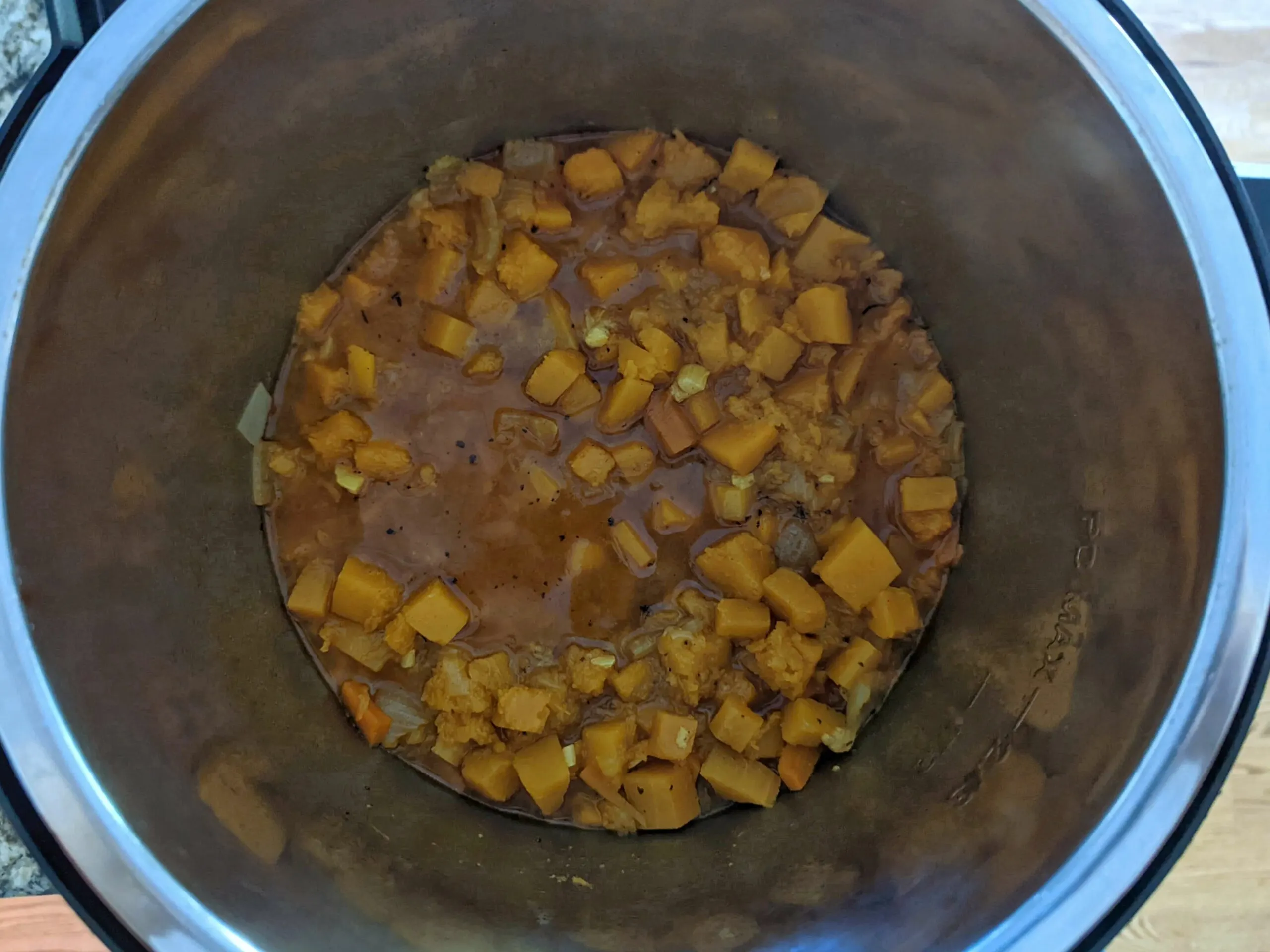 Vegetable stock poured over the vegetables cooking in the Instant Pot.