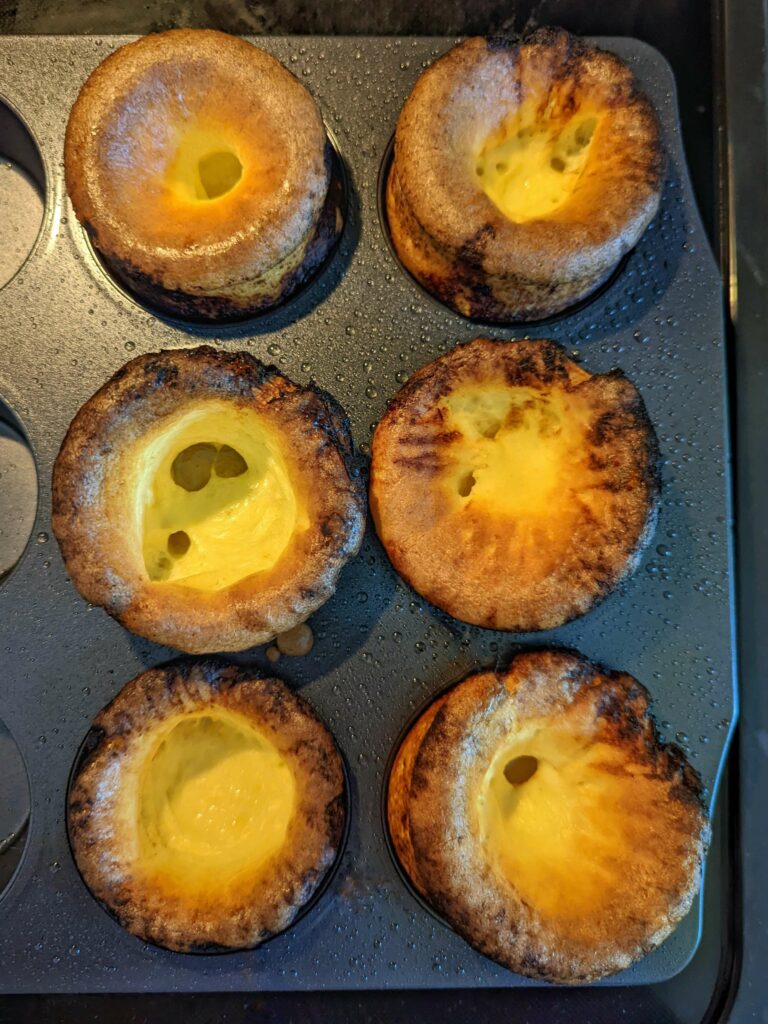 The keto Yorkshire puddings puffed up in the muffin tin.