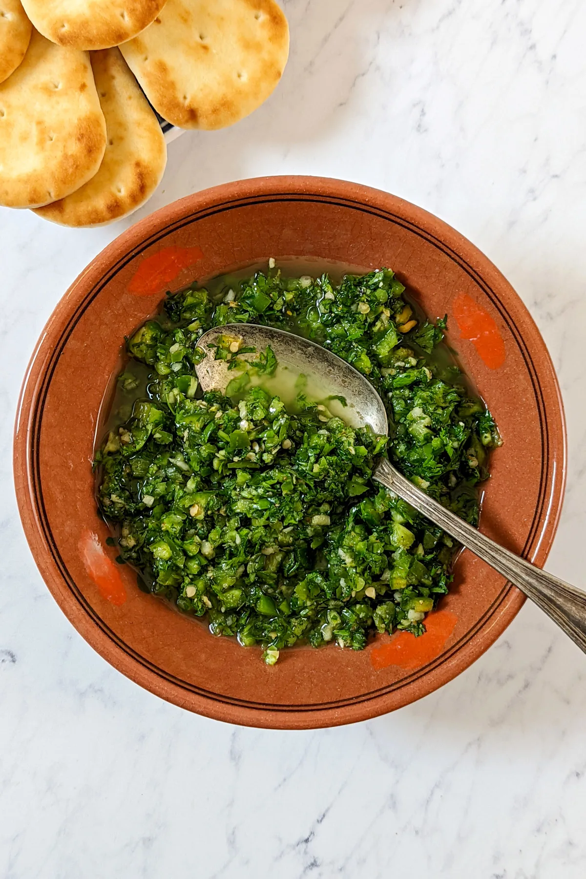 Easy Green Skhug 1 Skhug in a bowl with pita.