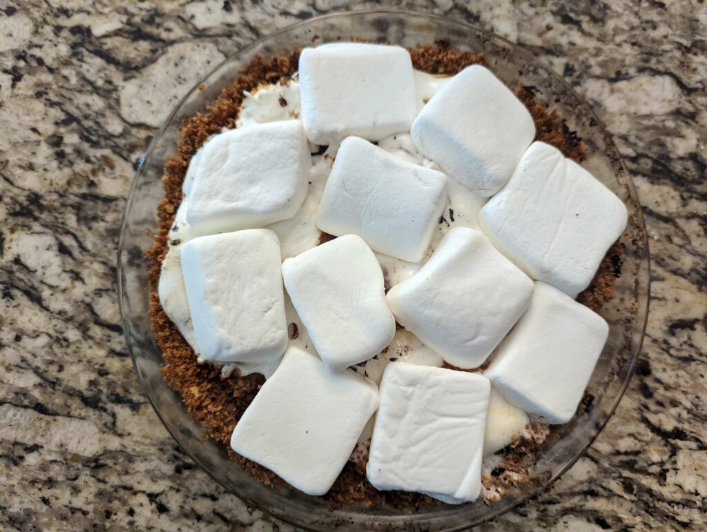 Marshmallows added to the prepared pie tin.
