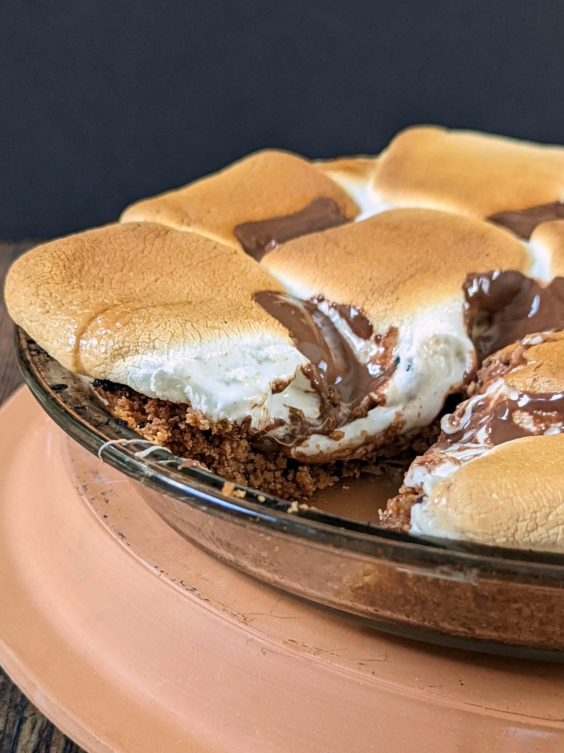 A full pan of smores pie ready to serve with one slice missing.