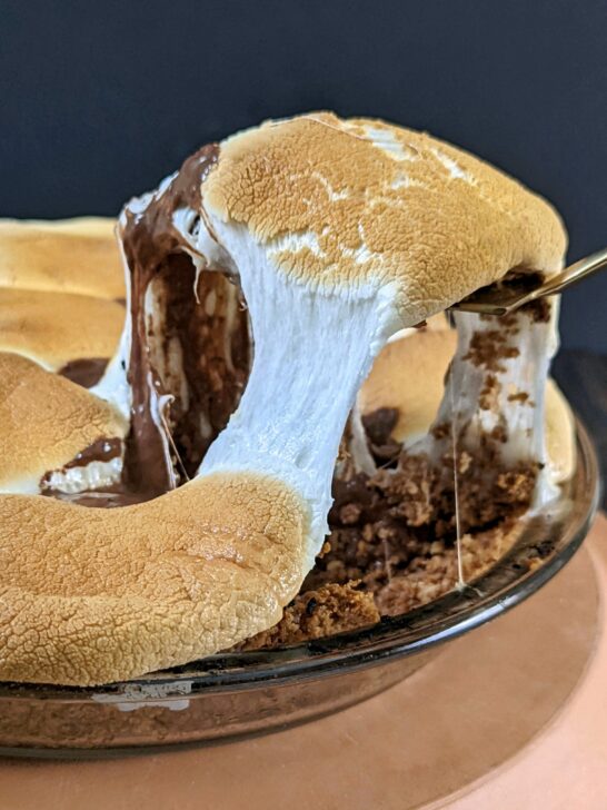 A slice of easy smores pie being scooped out of the pie dish.