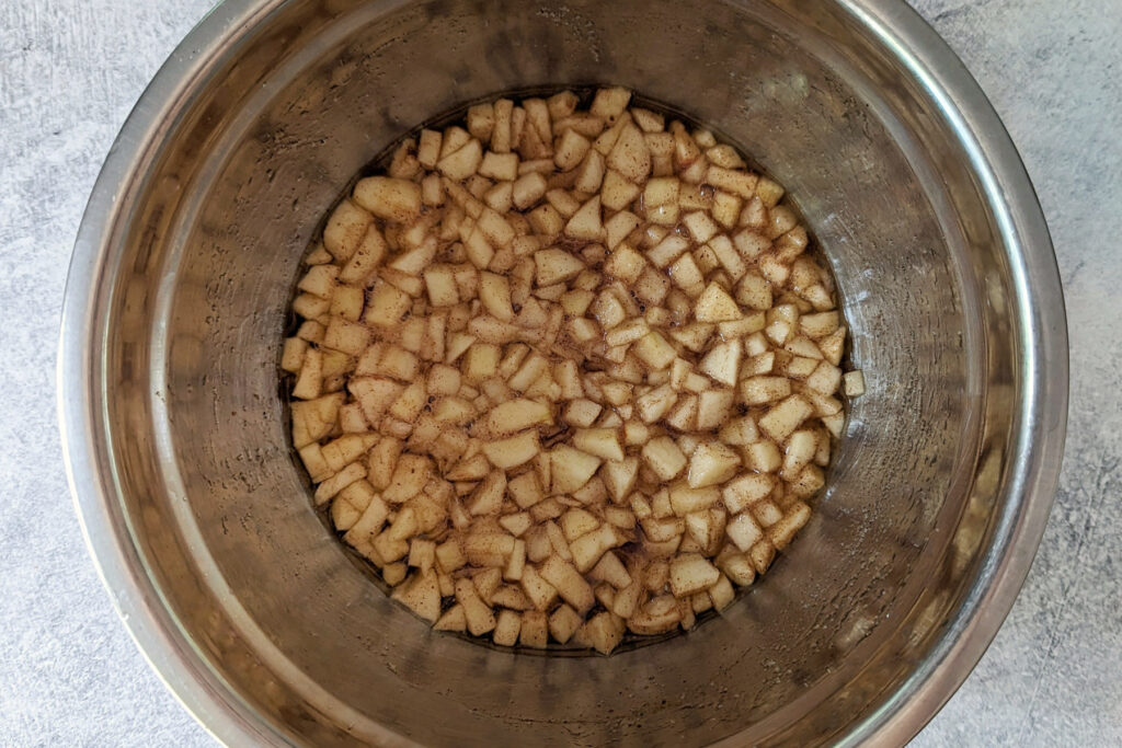 Apples, cinnamon sticks, and the ingredients for the simple syrup in a sauce pan. 