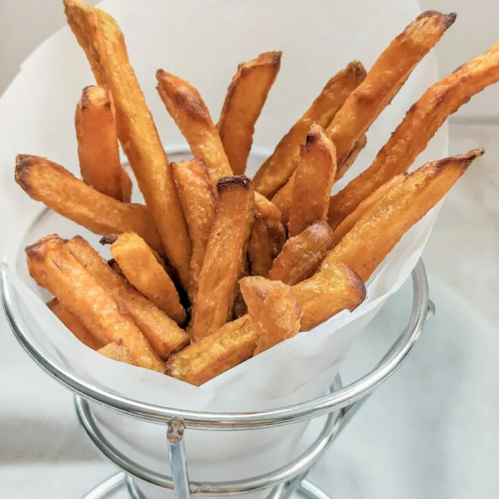 Air fryer sweet potato fries in a fry cup.
