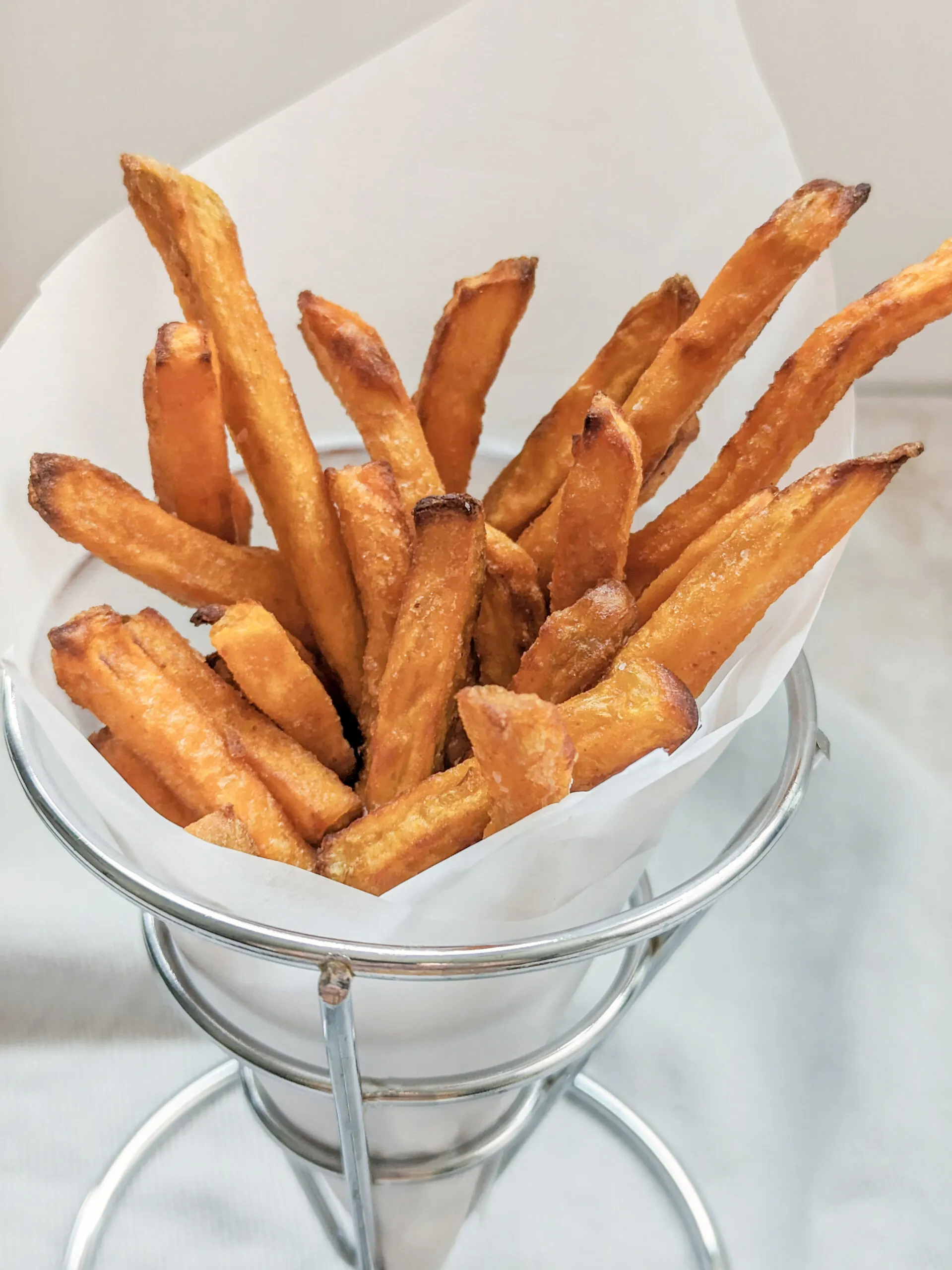 Air fryer sweet potato fries in a fry cup.