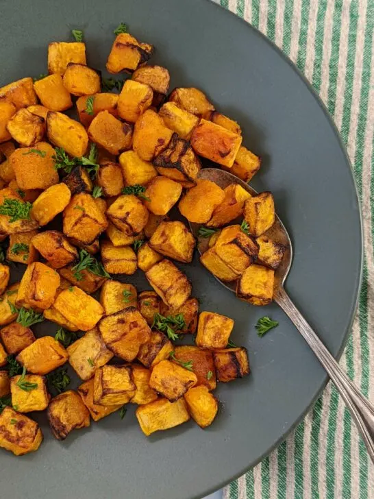A plate of butternut squash garnished with fresh parsley.