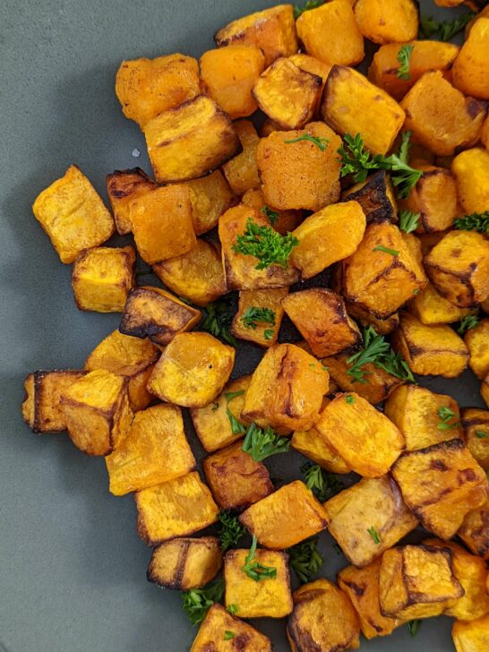 A plate of butternut squash garnished with fresh parsley.