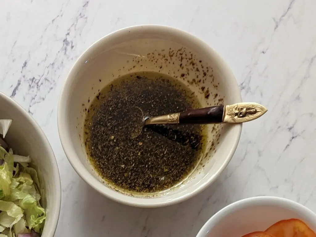 The ingredients for balsamic vinaigrette in a bowl.