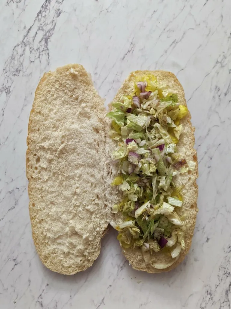 Bread topped with onion, lettuce, and pepperoncinis.