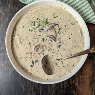 Keto cream of mushroom soup in a bowl topped with fresh parsley.