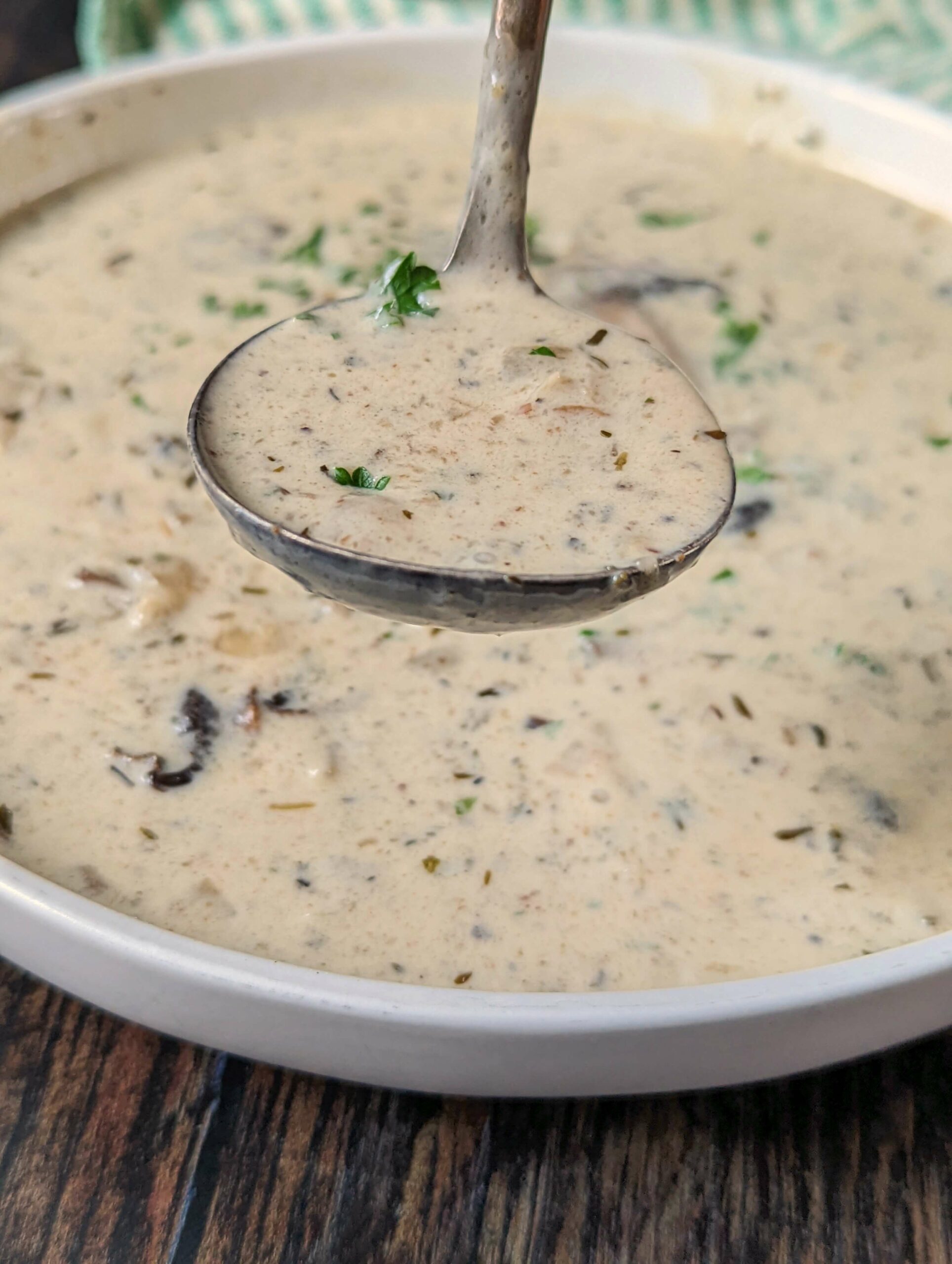 Keto cream of mushroom soup in a bowl topped with fresh parsley.