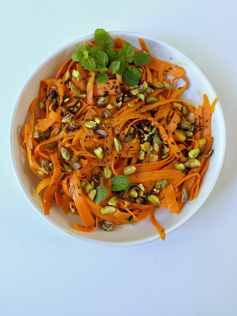 Moroccan carrot salad in a bowl topped with mint.