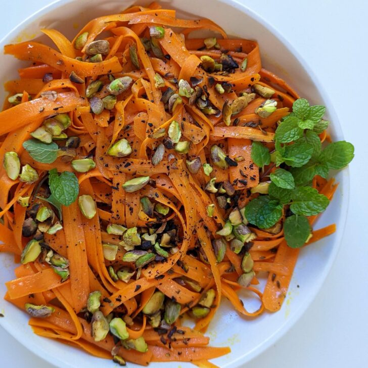 Moroccan carrot salad in a bowl topped with mint.