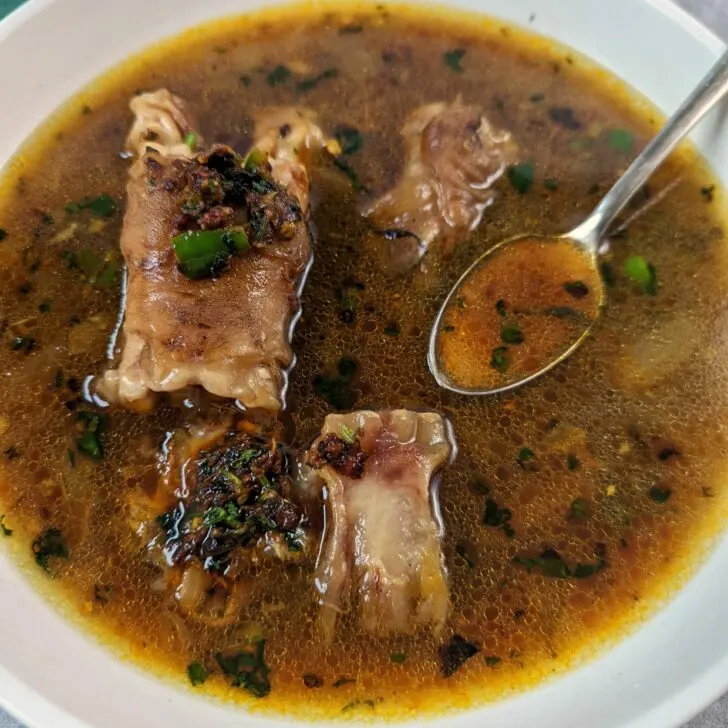 Mutton paya soup in a serving bowl.