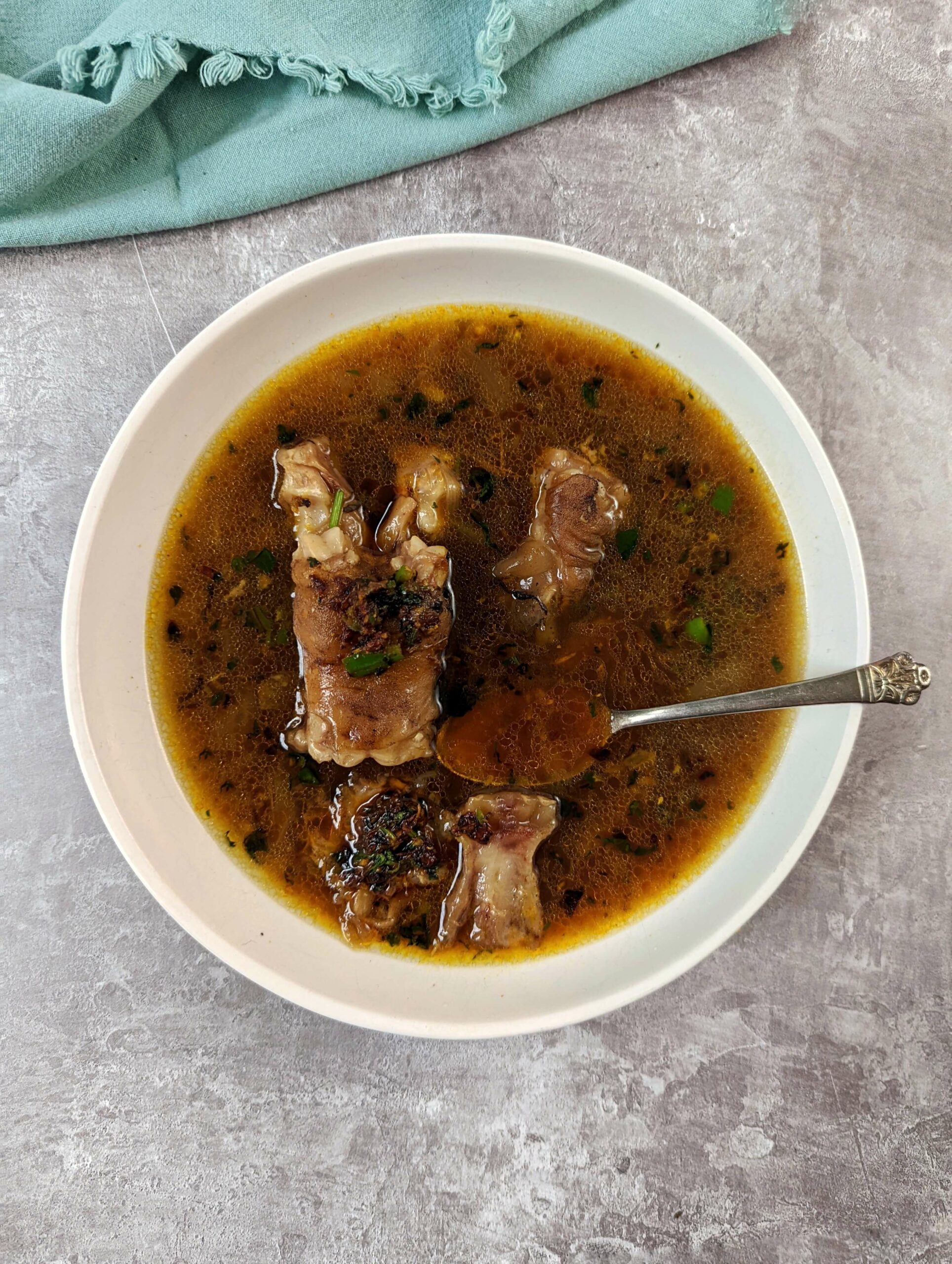 Mutton paya soup in a serving bowl.