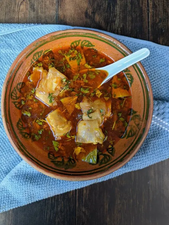 A bowl of paya soup topped with fresh cilantro.