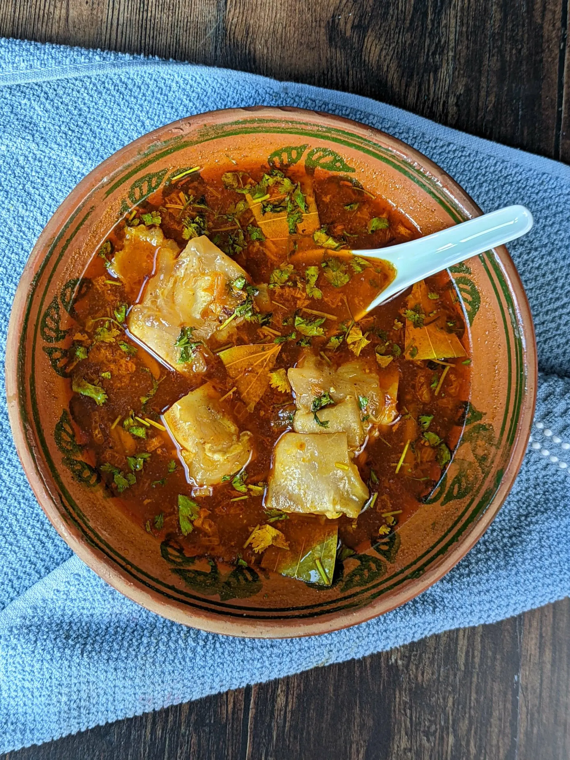 A bowl of paya soup topped with fresh cilantro.