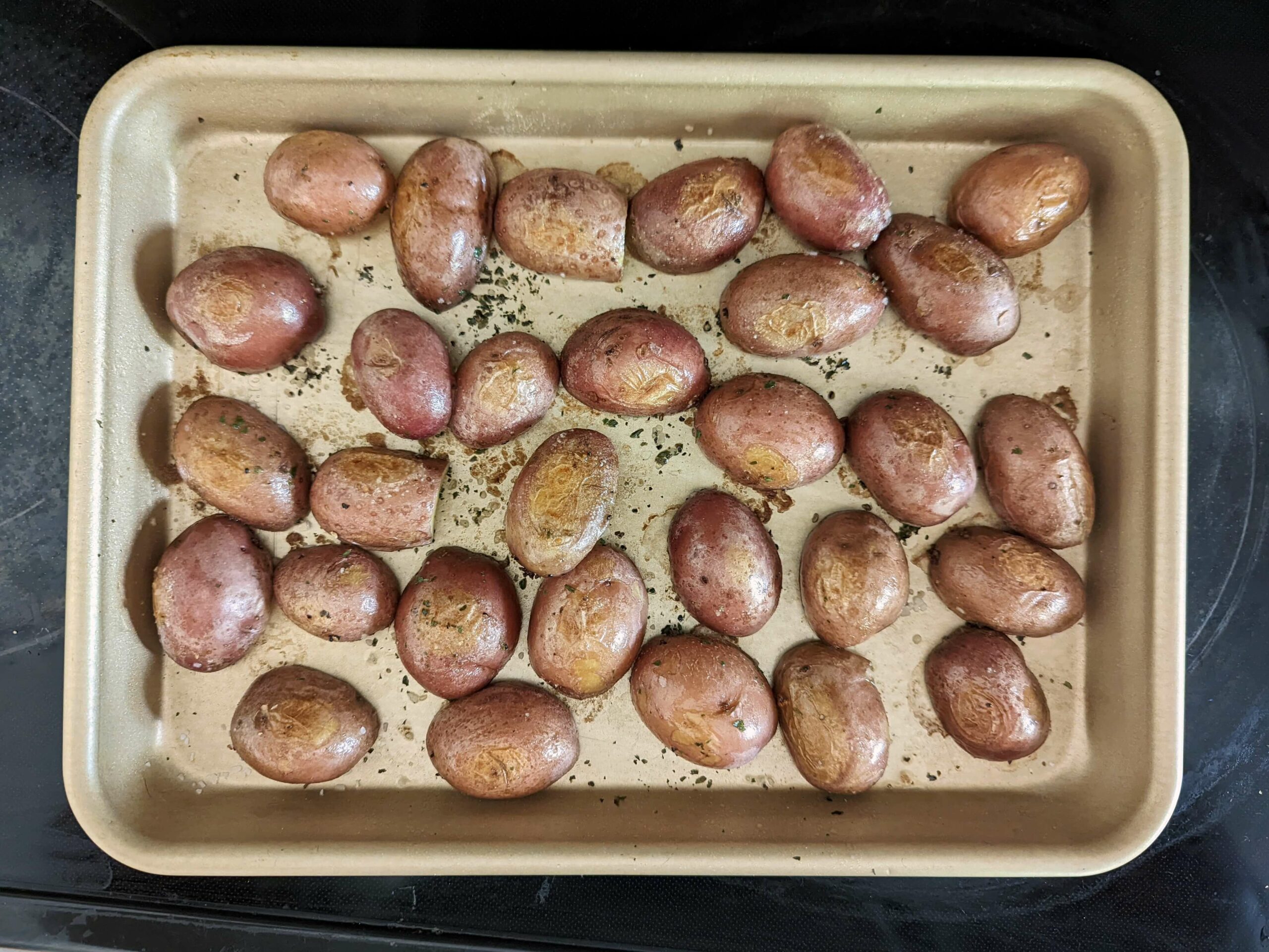 Yukon gold potatoes on a rimmed baking sheet.