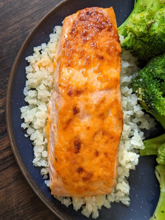 An overhead shot of Sriracha salmon over cauliflower rice and paired with roasted broccoli.