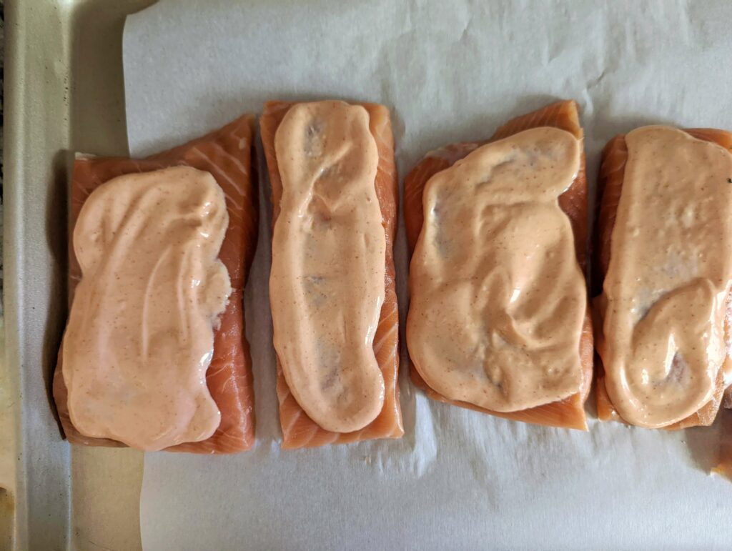 Salmon fillets coated with the mayonnaise mixture.